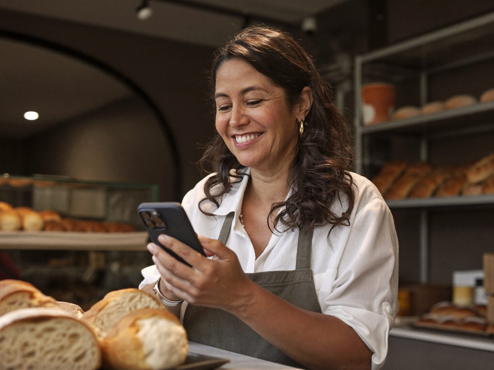 Empreendedora conferindo o movimento da loja pelo celular